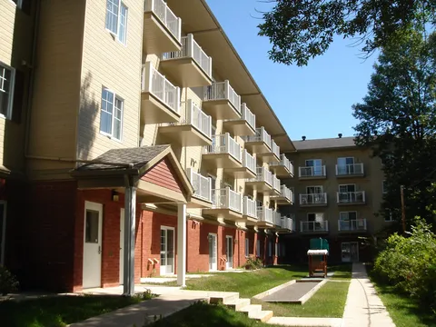 Residence courtyard with balconies, a lawn and a paved path beside the building