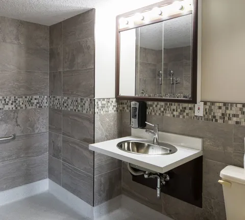 Bathroom with a sink, mirror and shower.