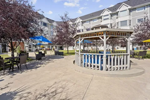 Courtyard with a gazebo, patio tables and the residence behind