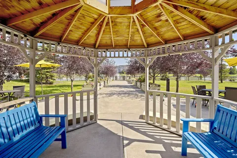 Inside a wooden gazebo with blue benches overlooking the courtyard