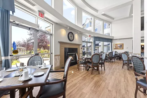 Dining room with set tables, large windows and a fireplace