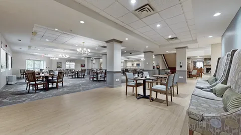 Dining tables and wooden chairs beside patterned upholstered seating