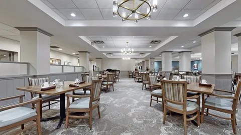 Dining room with wooden tables, striped chairs and ceiling lights