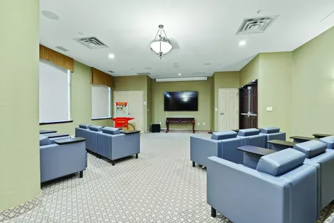 Room with blue armchairs facing a blank television