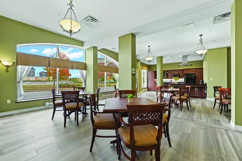 Room with tables, chairs and a wood-cabinet kitchen