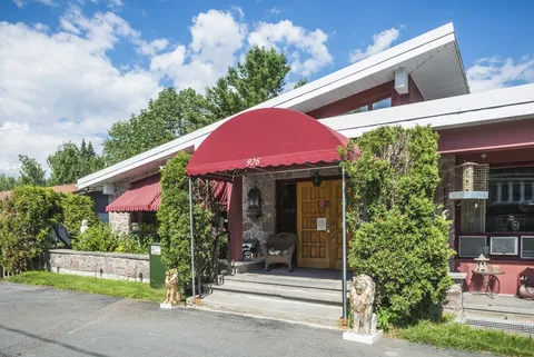 Single-storey residence with red entrance awning and front landscaping.