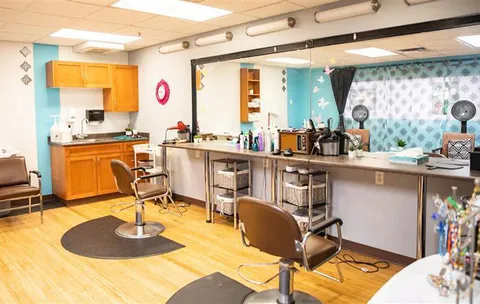 Salon with styling chairs, a long counter and mirrors
