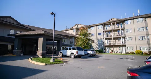 Residence exterior with a covered entrance, balconies and a curved driveway