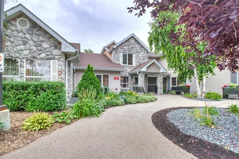 Residence exterior with a stone facade and landscaped entrance