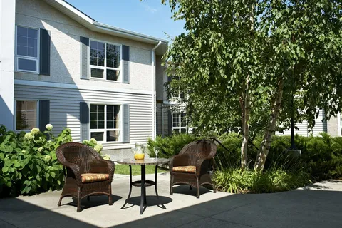 Patio seating beside trees and shrubs