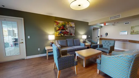 Lounge with sofas and armchairs beside glass patio doors