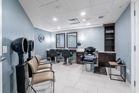 Hair salon with styling chairs, mirrors, hood dryers and a wash basin