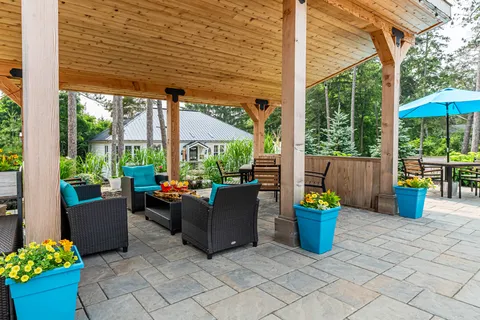 Covered patio with wicker chairs, turquoise cushions and flower planters