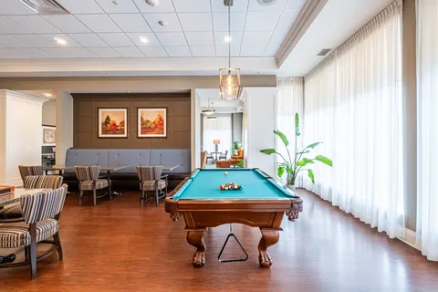 Games room with a billiards table, striped chairs and cushioned bench seating