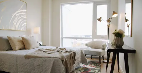 Bedroom with a double bed, bedside tables, a mirror and patterned grey bedding