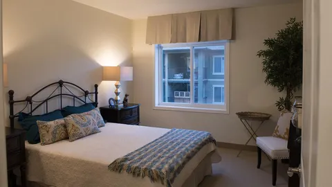 Suite bedroom with a double bed, side tables and a window.