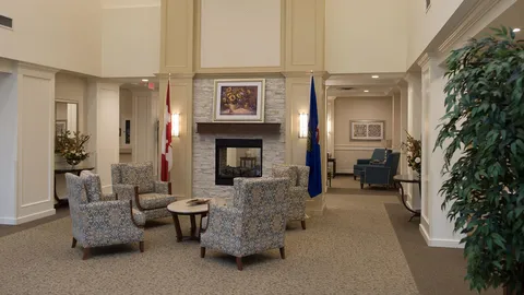 Lobby seating with patterned armchairs beside a fireplace.