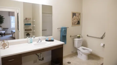 Accessible bathroom with a sink, toilet and grab rails.