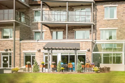Stone building with balconies, a patio and planted flower boxes