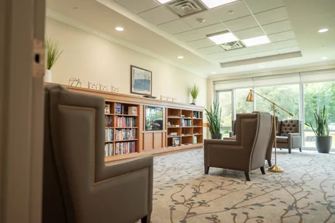 Library with armchairs, bookshelves and windows