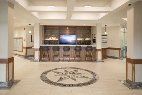 Lobby with a tiled compass design, a bar counter, stools and a television