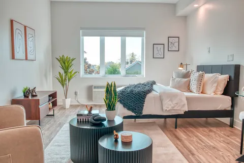 Studio suite with a bed, armchairs and large windows
