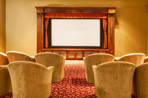 Cinema room with armchairs facing a projection screen