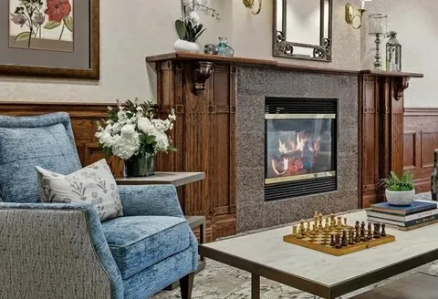Fireside lounge with blue seating and a chessboard.