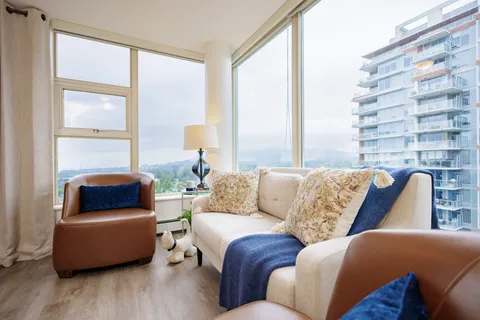 Sitting area with a sofa and brown armchairs beside corner windows