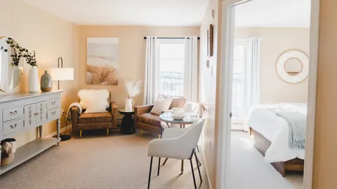 Suite sitting area and bedroom viewed through an open doorway.