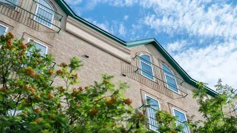 Brick exterior with balconies and trees.