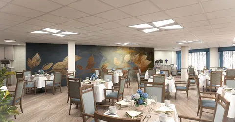 Dining room with set tables, upholstered chairs and a large leaf mural