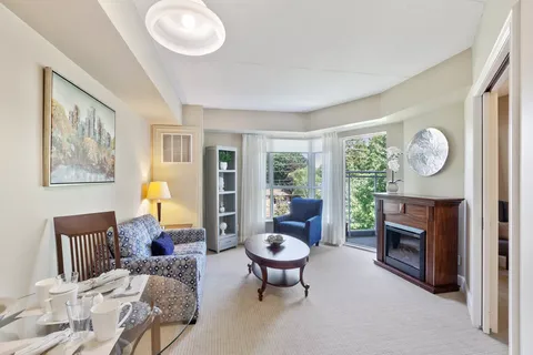 Sitting area with patterned chairs, a fireplace and a round coffee table