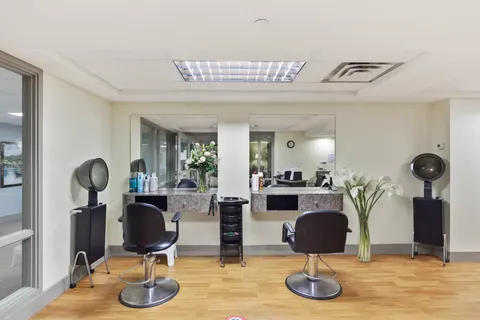 Salon with two styling chairs, mirrors and hair dryers