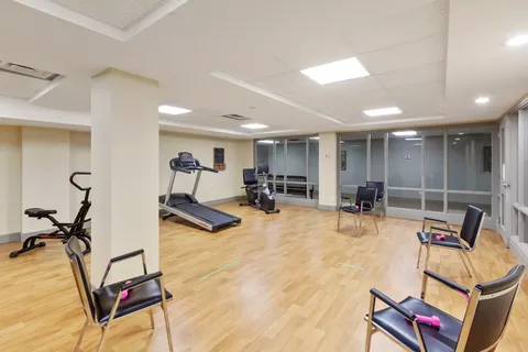 Fitness room with exercise machines, chairs and large glass panels