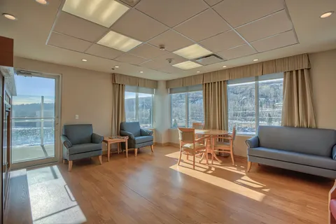 Lounge with blue seating, wooden tables and large windows