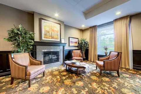 Room with armchairs, a fireplace and large windows