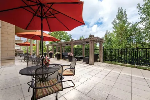 Patio with red umbrellas, tables and a pergola
