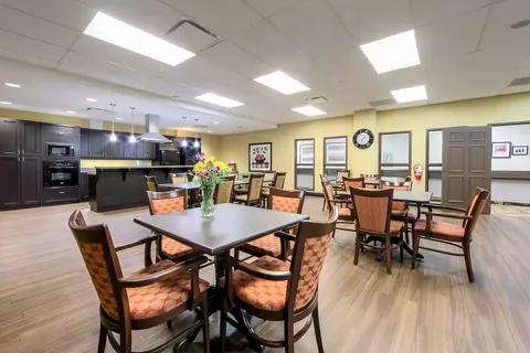 Room with a kitchen counter, tables and chairs