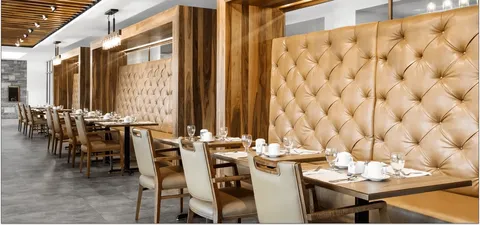Dining tables and chairs beside a padded wall
