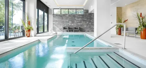 Indoor swimming pool with steps and a metal handrail