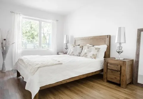 Bedroom with a wooden bed, matching bedside tables and white bedding