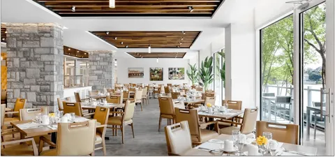 Dining room with set tables, wooden chairs and stone columns