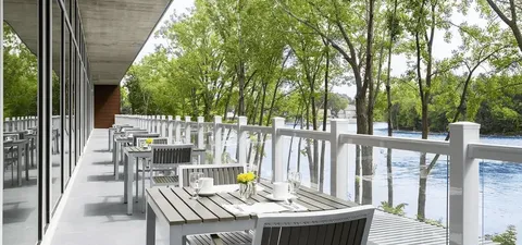 Waterside terrace with tables, chairs and glass railings