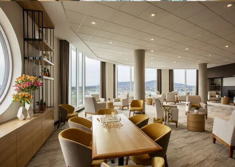 Windowed lounge with seating and a curved exterior view.