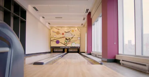 Bowling lanes with seating at the near end.