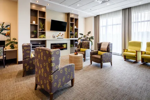 Care-unit lounge with armchairs and built-in shelving.