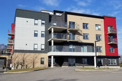 Grey, beige and red building with balconies and a covered entrance