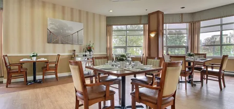 Dining room with wooden chairs, set tables and large corner windows