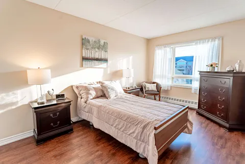 Bedroom with a double bed, bedside tables, lamps, a dresser and large window